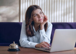 Gestora analisando demanda previsível na hotelaria pelo notebook para reduzir os efeitos da sazonalidade